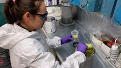 A materials engineer from the Naval Air Warfare Center Aircraft Division prepares to spray a qualified paint product in a corrosion lab at Naval Air Station Patuxent River.